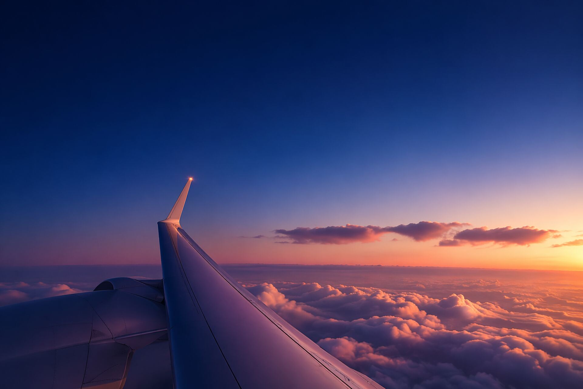 Airplane wing at sunset above the clouds